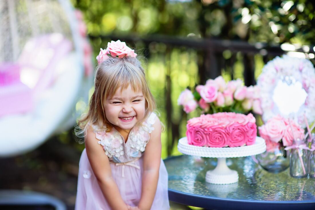 Funny happy giggly little girl in pink dress with pink cake Picture