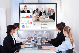 business people at a hybrid event meeting on large screen tvPicture