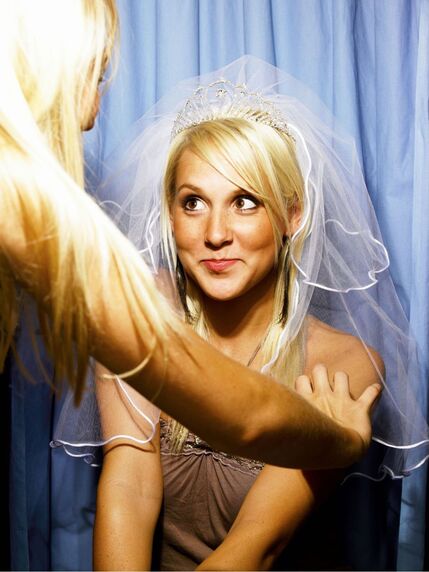 Funny picture of young bride to be allowing her friend to primp and pose her for the photo booth Picture