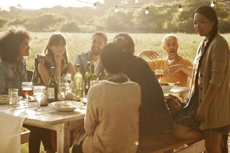 Friends and family at picnic table in nature telling stories of departed loved one Picture