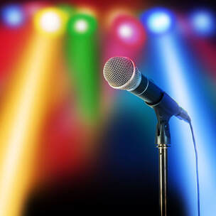 Microphone on stand with colorful DJ lights in background Picture