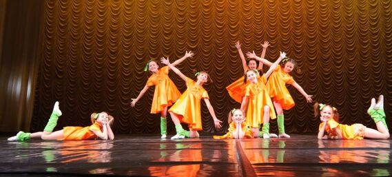 Adorable kids wearing bright orange and green in a play Picture