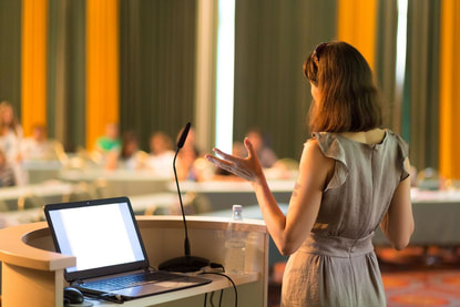 Woman giving a presentation in large conference room Picture