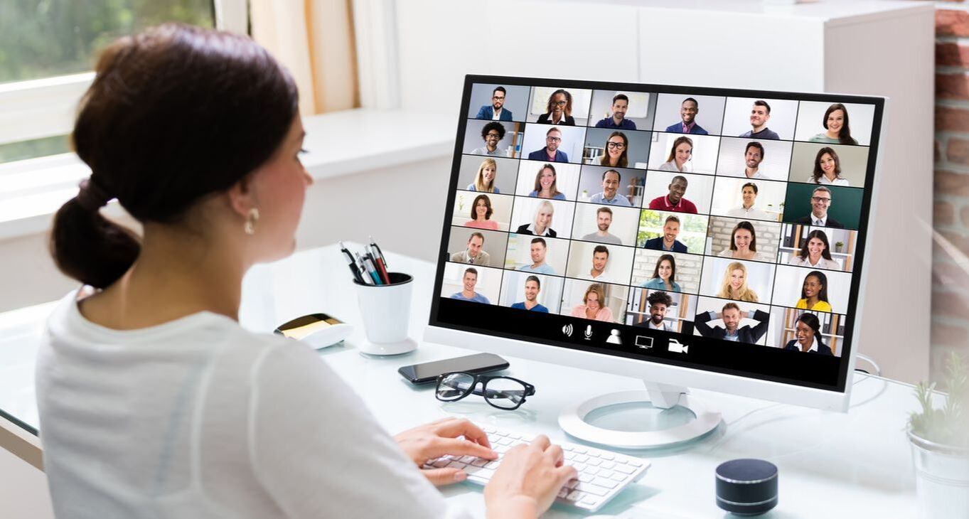 Woman looking at large group of Zoom members on screen Picture