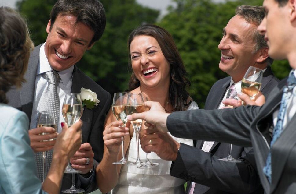 Joyful bride and groom toasting with friends at wedding reception Picture