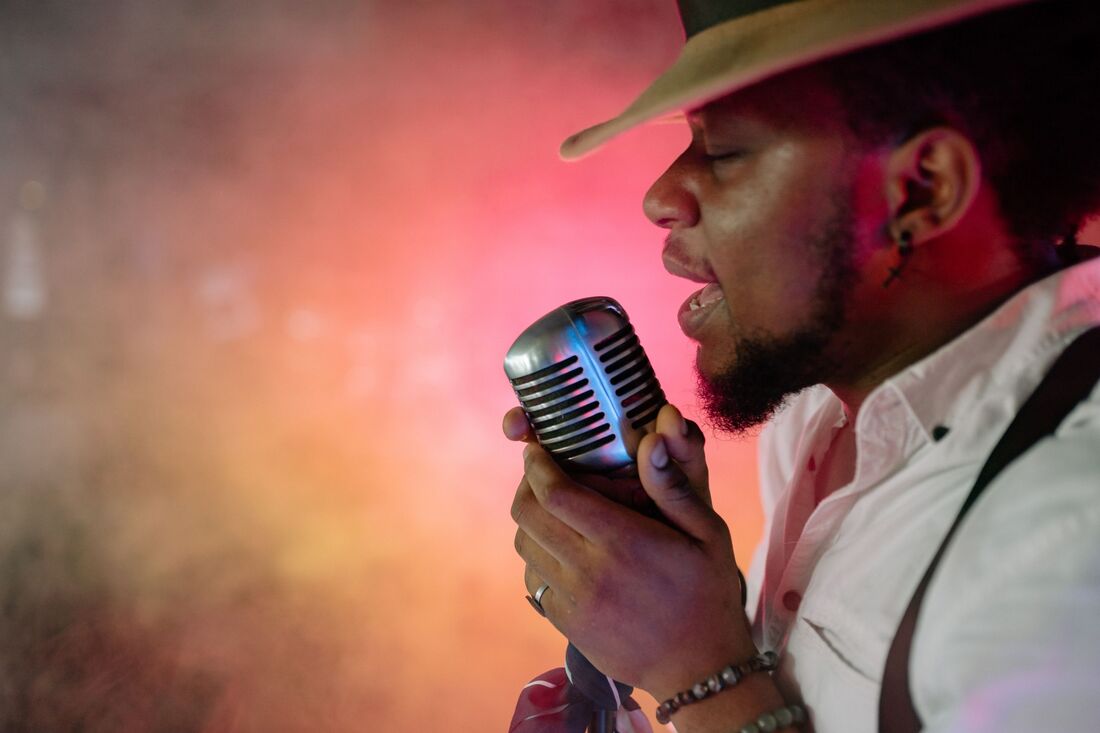 Handsome man in hat crooning into old time microphone Picture