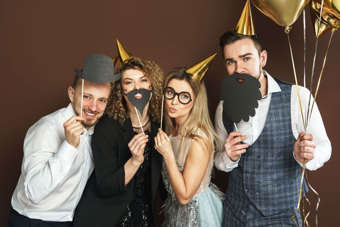 4 people in formal attire with props and gold hats and balloons Picture