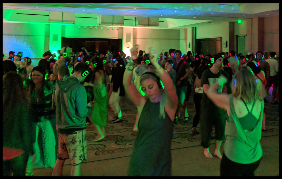 Young people with LED headphones dancing in large room to silent disco Picture